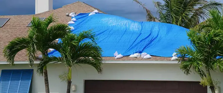Emergency roof tarping on a storm-damaged Central Florida home